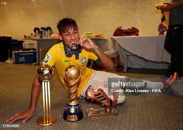 Neymar of Brazil poses with the trophy and his adidas Golden Ball and Bronze boot awards in the dressing room at the end of the FIFA Confederations...