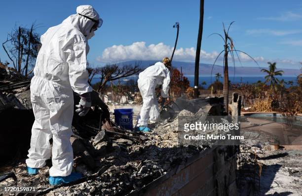 Displaced residents Caroline Anthony and Lori Brodeur search for personal items in the rubble of the wildfire destroyed home where they lived on...
