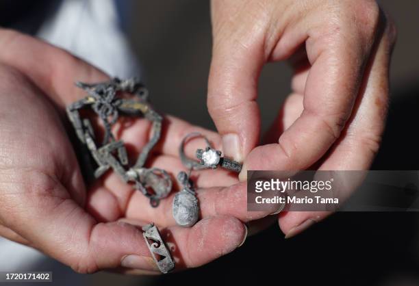 Displaced resident Lori Brodeur displays jewelry found by volunteers from Samaritan's Purse who sifted through the ashes of the wildfire destroyed...