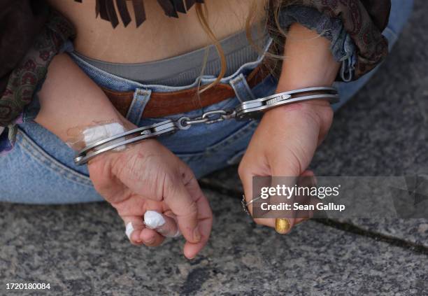 Police detain a climate activist in handcuffs from the group "Last Generation" who was going to glue herself to the asphalt at Potsdamer Platz on...