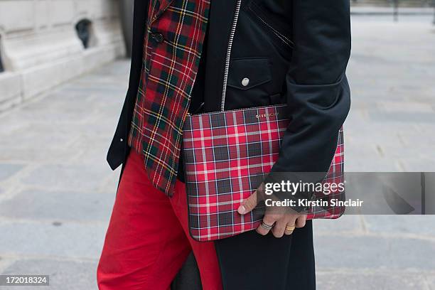 And Fashion blogger Peter Xu wears 5cm trousers, a Comme des Garcons jacket and tops with a Givenchy clutch bag on day 3 of Paris Collections: Men on...