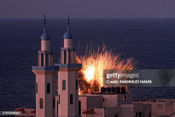 Fireball erupts from an Israeli airstrike in Gaza City on October 12, 2023. Thousands of people, both Israeli and Palestinian, have died since...