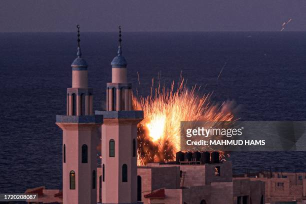 Fireball erupts from an Israeli airstrike in Gaza City on October 12, 2023. Thousands of people, both Israeli and Palestinian, have died since...