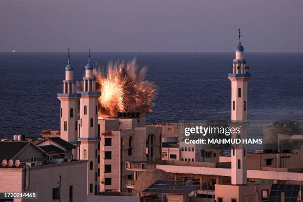 Fireball erupts from an Israeli airstrike in Gaza City on October 12, 2023. Thousands of people, both Israeli and Palestinian, have died since...