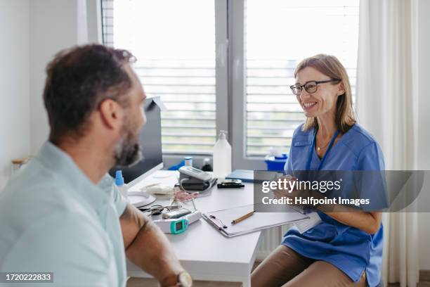 patient visiting the general practitioner for their annual physical exam. - gesundheitsvorsorge stock-fotos und bilder