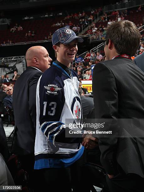 Eric Comrie, drafted overall in the second round by the Winnipeg Jets, visits with members of the Jets' organization after he was drafted during the...