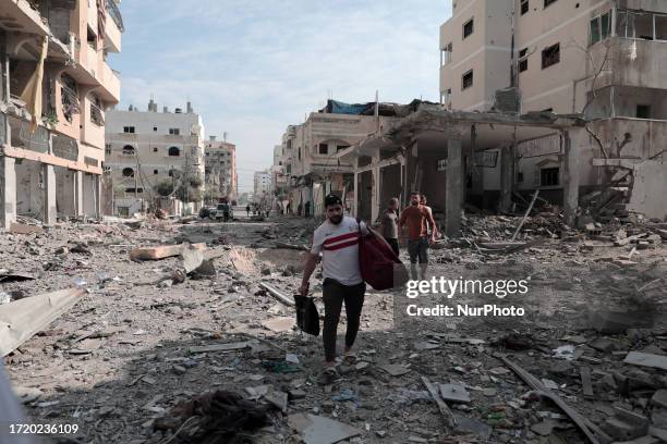 Palestinian families evacuates to safer areas following overnight Israeli shelling in Gaza city on October 11, 2023.