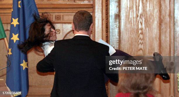Hungarian Prime Minister Ferenc Gyurcsany carries government spokesperson Bernadette Budai after she collapsed during a press conference at the...