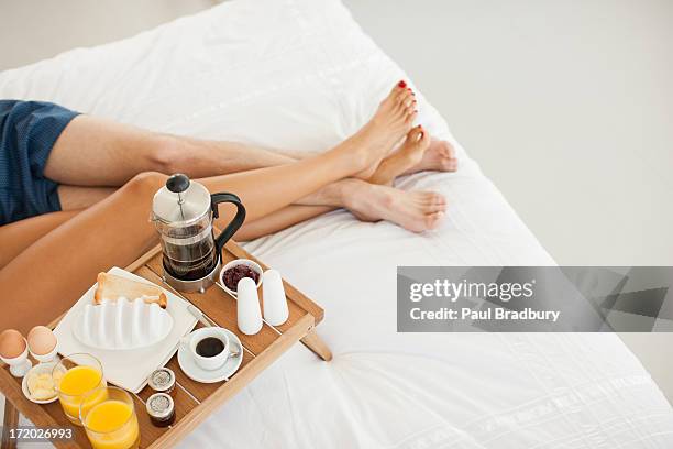 pareja con un desayuno en la cama - man touching womans leg fotografías e imágenes de stock