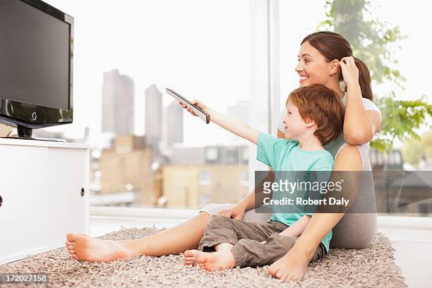 mother and son watching television - boy at television stockfoto's en -beelden