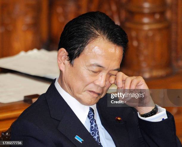 Japanese Prime Minister Taro Aso rubs his eyes during an Upper House plenary session as an opposition proposed budget bill that excluded a government...