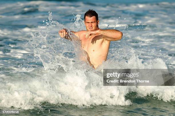 James Horwill is hit by a wave during an Australian Wallabies recovery session at Coogee Beach on July 1, 2013 in Sydney, Australia.