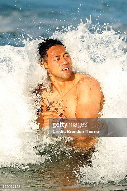 Christian Leali'ifano is hit by a wave during an Australian Wallabies recovery session at Coogee Beach on July 1, 2013 in Sydney, Australia.