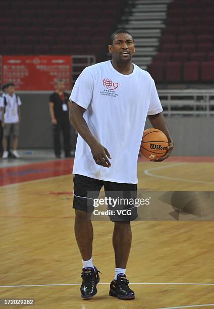 Metta World Peace of Los Angeles Lakers plays basketball with children at MasterCard Center on June 30, 2013 in Beijing, China.