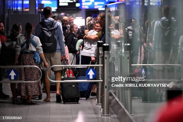 Passengers react upon arrival at Frankfurt International Airport, Frankfurt am Main, western Germany on October 12 after a first flight by German...