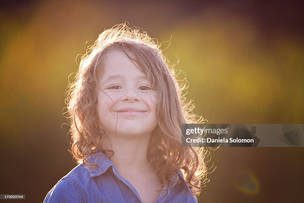 Smiling boy with long hair, sunset time