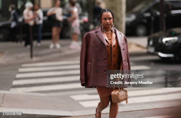 Paola Locatelli is seen wearing a cognac leather jacket, a red-brown oversized leather jacket, an orange dress and a brown Arcadie Miu Miu handbag...