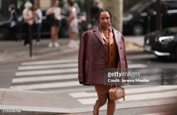 Paola Locatelli is seen wearing a cognac leather jacket, a red-brown oversized leather jacket, an orange dress and a brown Arcadie Miu Miu handbag...