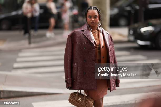 Paola Locatelli is seen wearing a cognac leather jacket, a red-brown oversized leather jacket, an orange dress and a brown Arcadie Miu Miu handbag...