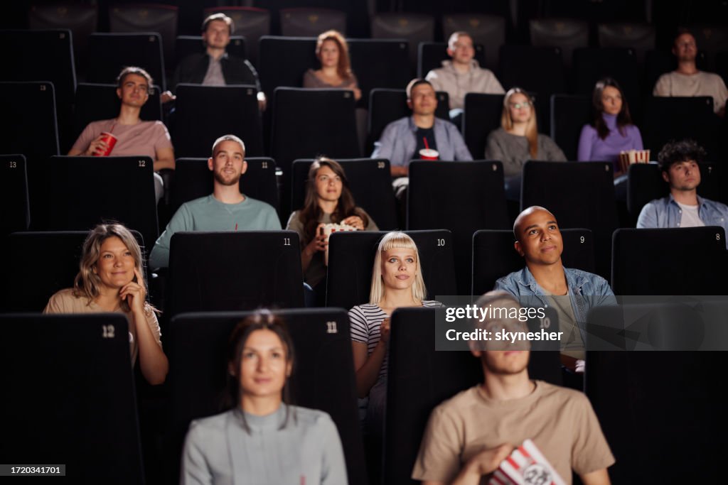 Large group of people watching a movie in cinema.