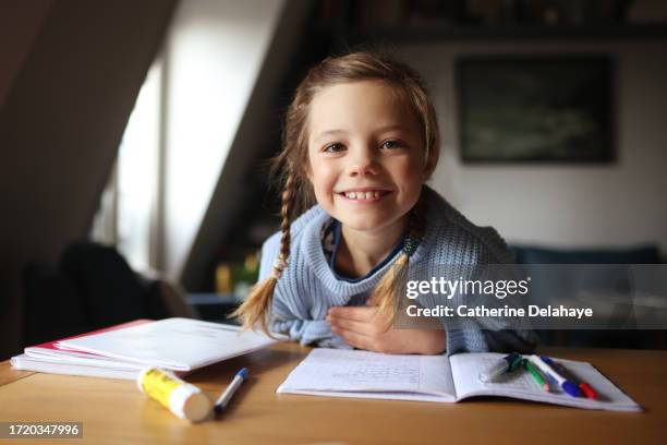an 8 year old girl doing her homework at home - deberes fotografías e imágenes de stock