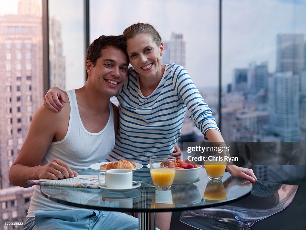 Couple hugging with breakfast on the table