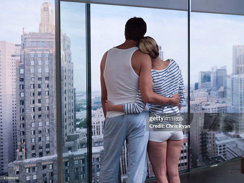 Couple hugging and looking outside 