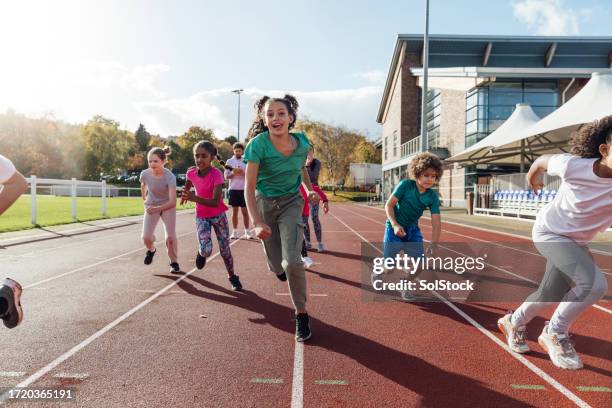 children running on track - child running stock pictures, royalty-free photos & images