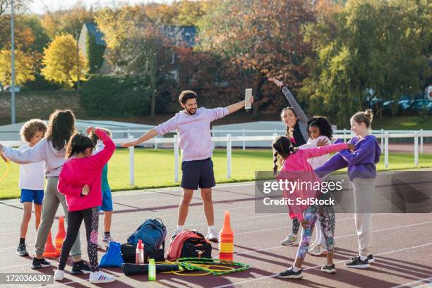 kids stretching on the track - 40 44 years stock pictures, royalty-free photos & images