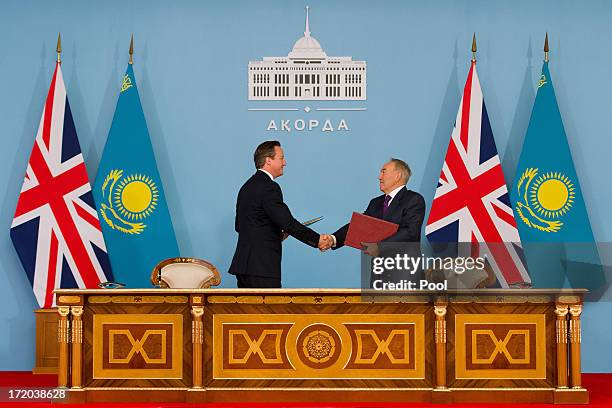 British Prime Minister David Cameron shakes hands with Kazakhstan President Nursultan Nazarbayev after signing a strategic partnership agreement at...