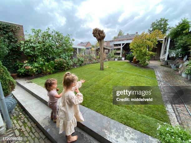 grandchildren watching the garden - sod field stock pictures, royalty-free photos & images