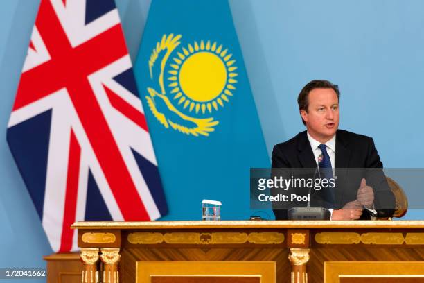 British Prime Minister David Cameron listens to questions during a joint press conference with President Nursultan Nazarbayev after signing a...