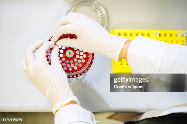 scientist gloved hands loading centrifuge in lab directly above - test tubes above stock pictures, royalty-free photos & images