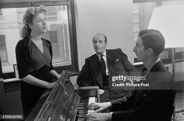 British bandleader Bert Ambrose listening to singer Stella John during a rehearsal at the May Fair Hotel in London, circa 1945. Original Publication:...