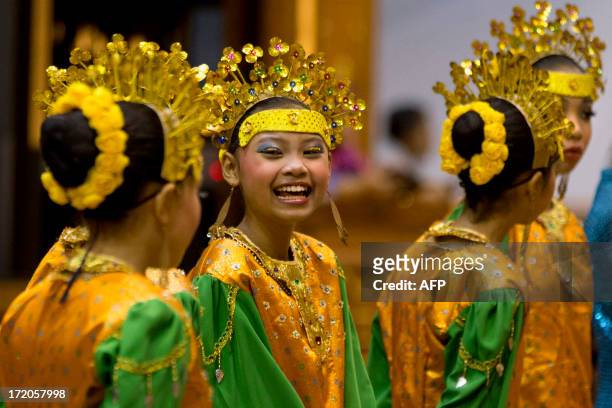 Girls wearing traditional costumes from Brunai laugh as they wait to greet foreign ministers before a cultural event attended by U.S. Secretary of...