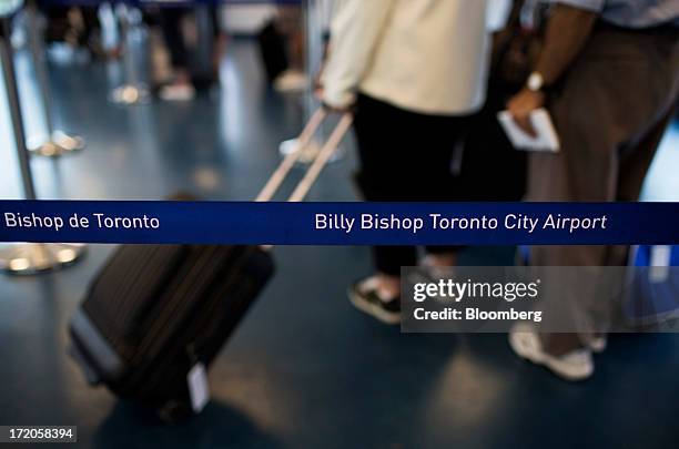 Travelers wait in line at Billy Bishop Toronto City Airport in Toronto, Ontario, Canada, on Friday, June 28, 2013. Porter Airlines Inc., the Canadian...
