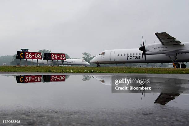 Porter Airlines Inc. Aircrafts taxi on the runways at Billy Bishop Toronto City Airport in Toronto, Ontario, Canada, on Friday, June 28, 2013. Porter...