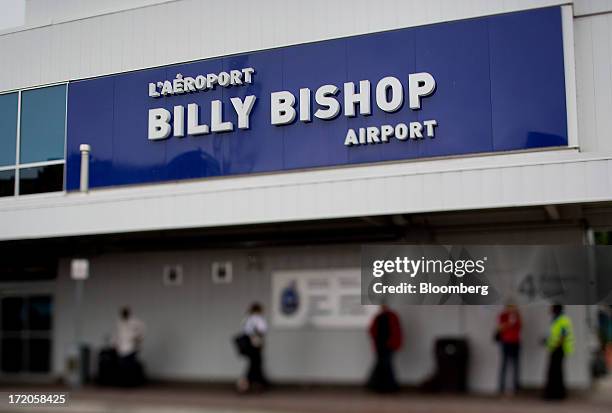 Travelers are seen standing outside in this photo taken with a tilt-shift lens at Billy Bishop Toronto City Airport in Toronto, Ontario, Canada, on...