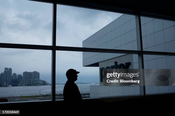 The silhouette of a traveler is seen standing near Porter Airlines Inc. Signage at Billy Bishop Toronto City Airport in Toronto, Ontario, Canada, on...