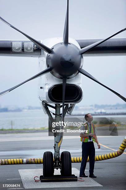 Porter Airlines Inc. Ground staff inspects an aircraft at Billy Bishop Toronto City Airport in Toronto, Ontario, Canada, on Friday, June 28, 2013....