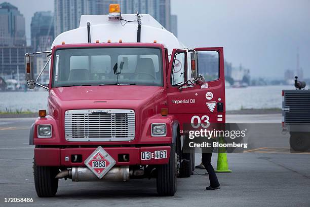 Worker climbs into an Imperial Oil truck on the tarmac at Billy Bishop Toronto City Airport in Toronto, Ontario, Canada, on Friday, June 28, 2013....