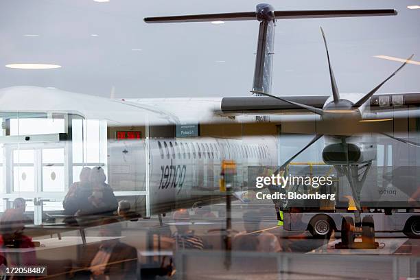 Porter Airlines Inc. Aircraft is reflected in a window at Billy Bishop Toronto City Airport in Toronto, Ontario, Canada, on Friday, June 28, 2013....