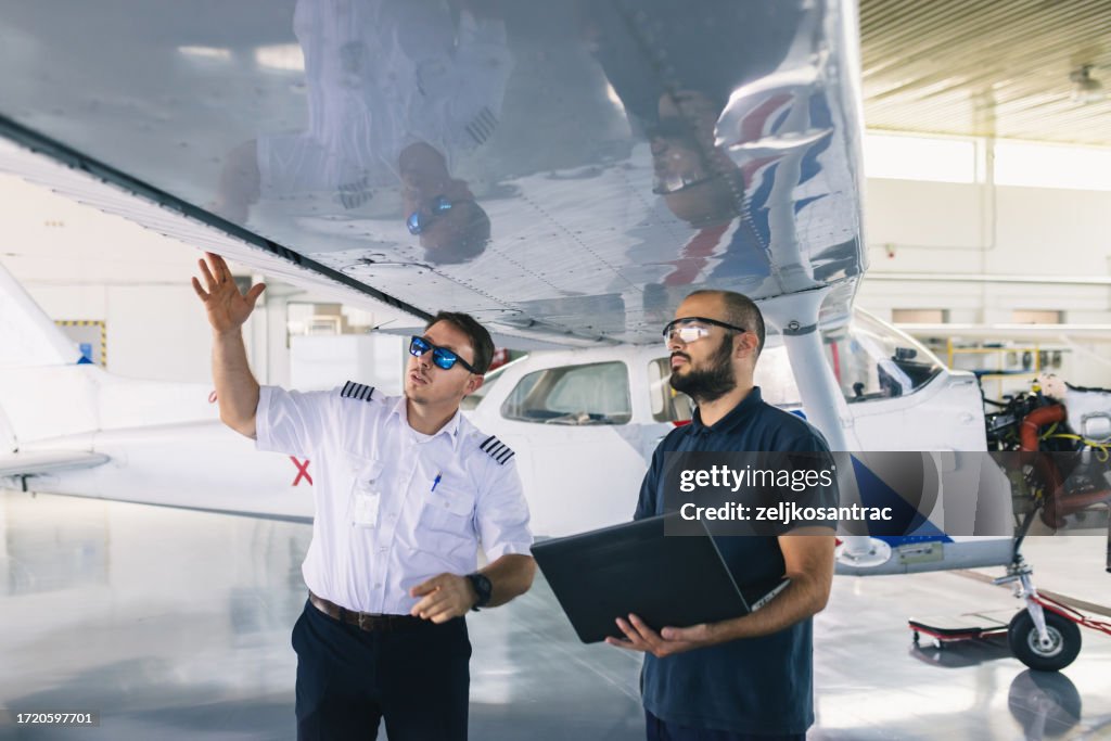 El mecánico de la aeronave y el piloto inspeccionan el avión antes del despegue
