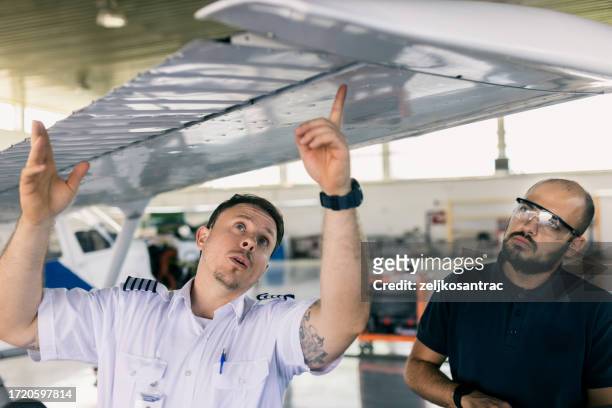 der fluggerätmechaniker und der pilot inspizieren das flugzeug vor dem start - private aeroplane stock-fotos und bilder