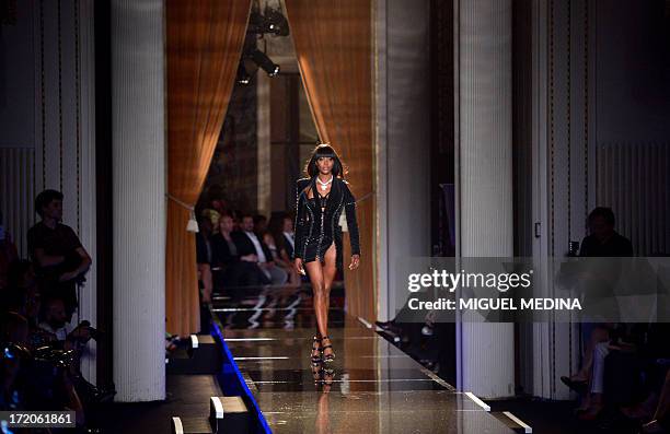 British model Naomi Campbell presents a creation by Italian fashion designer Donatella Versace during the Haute Couture Fall/Winter 2013-2014 Versace...