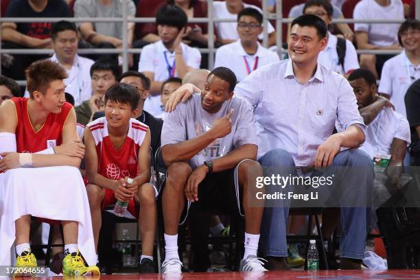 Yao Ming and NBA star Tracy McGrady watch the Yao Foundation Charity Game, sponsored by the charity foundation initiated by former Chinese basketball...