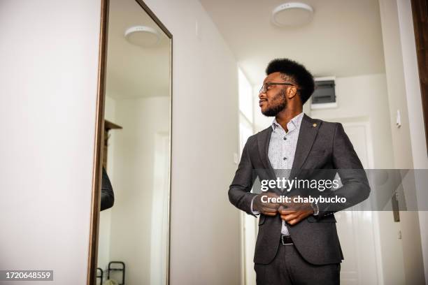 hombre de negocios de moda mirándose en el espejo - vestirse fotografías e imágenes de stock