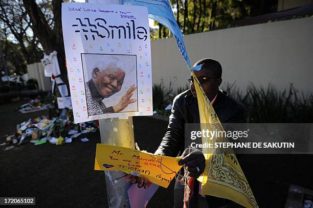 Housekeepers removes well wishing messages left for former South African President Nelson Mandela outside his house on July 1, 2013 in Johannesburg....