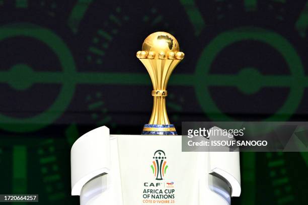 The trophy of the Africa Cup of Nations is pictured on the stage during the CAN 2024 official draw at Parc des Expositions in Abidjan, southeastern...