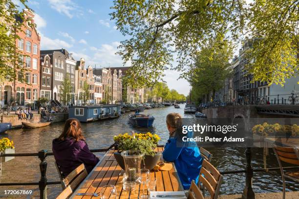 outdoor restaurant overlooking canal, amsterdam - sidewalk cafe stock pictures, royalty-free photos & images